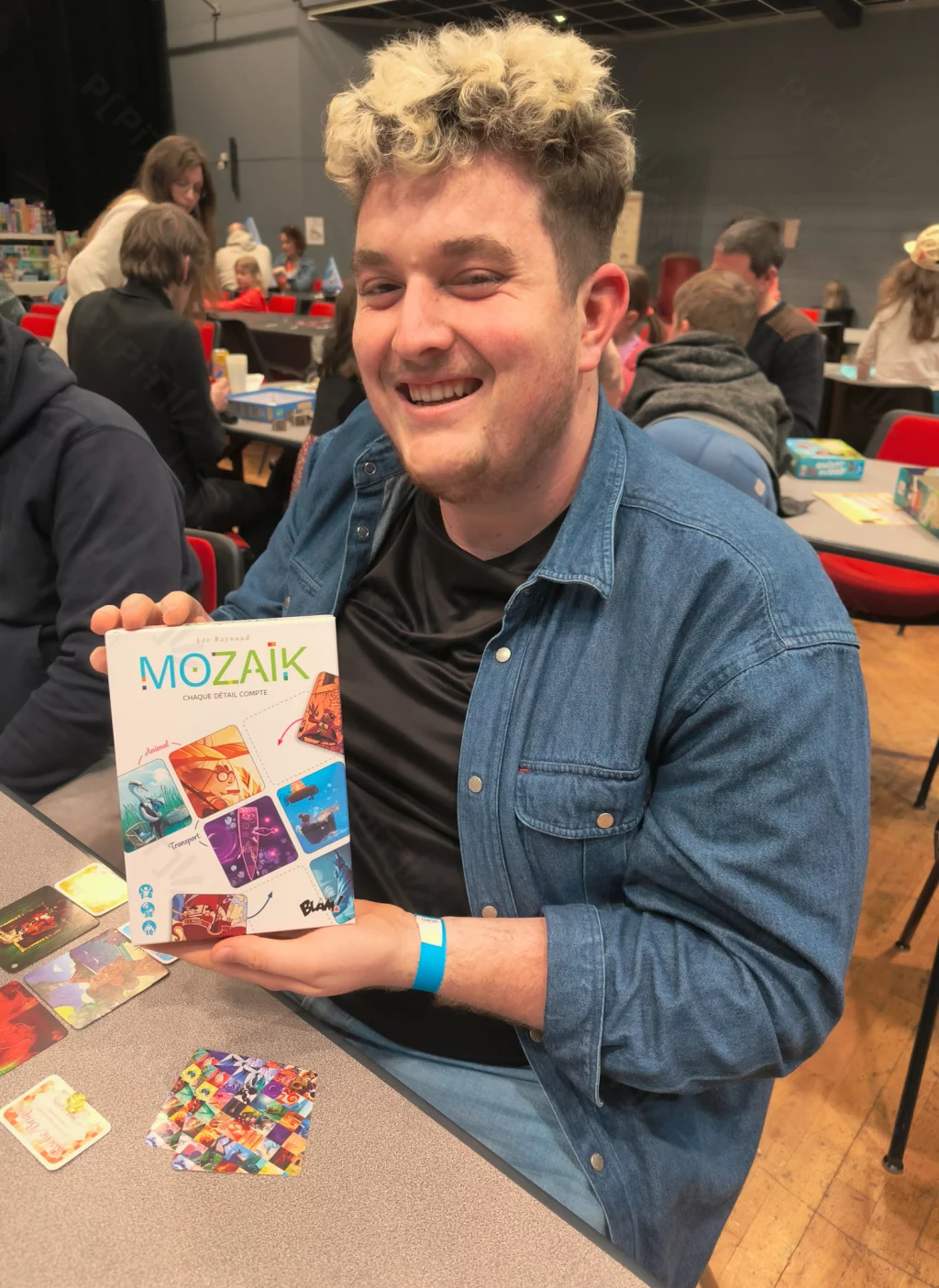 Un sourire qui en dit long… et une boîte de jeu qui donne envie de s’installer à table.